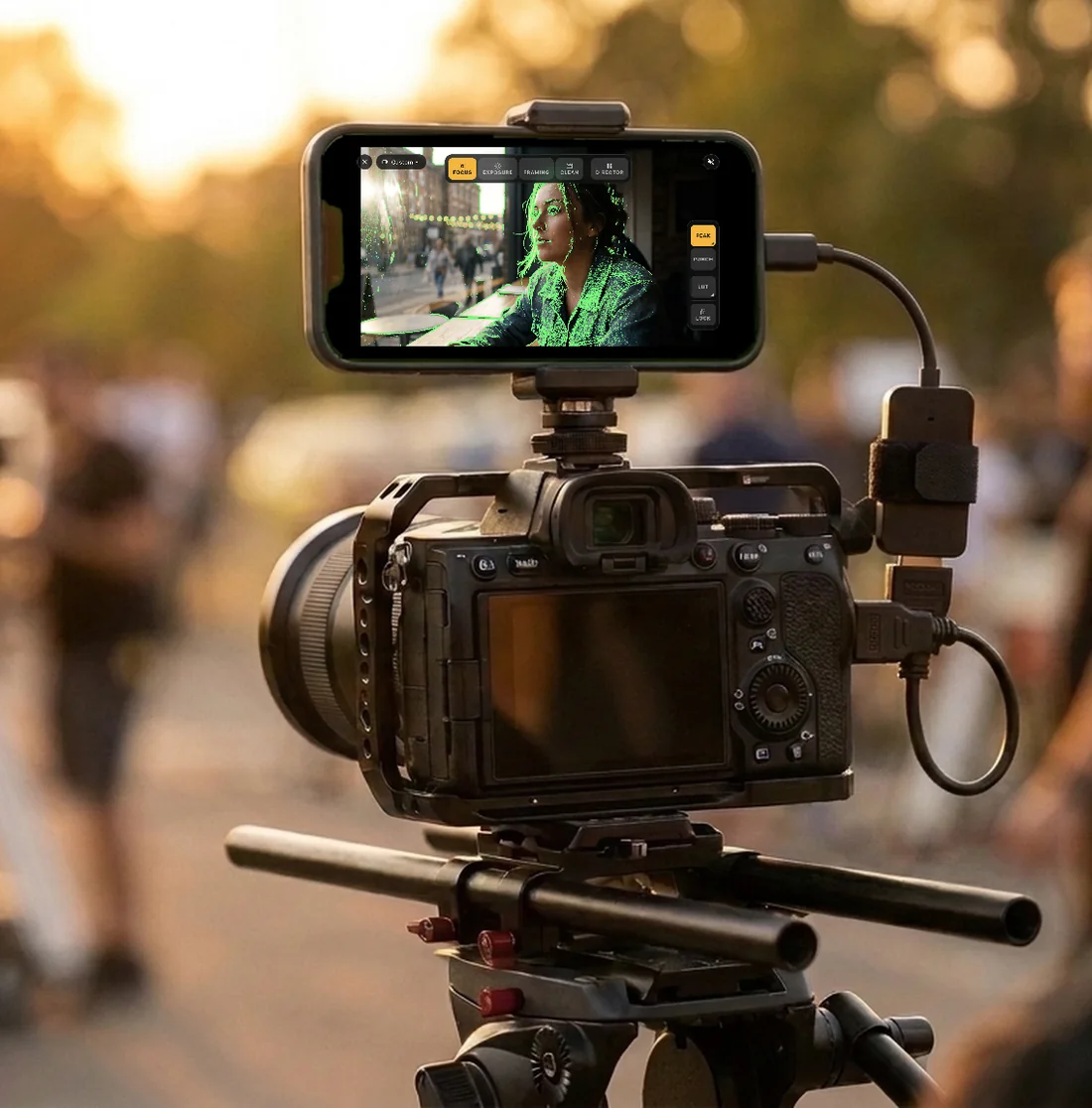 A smartphone mounted on a camera rig, running Field Monitor with green focus peaking on a portrait